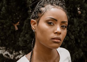Stunning portrait of a woman with braided hair, showcasing beauty and fashion outdoors.